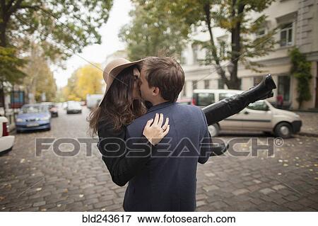 Caucasian man carrying and kissing woman on cobblestone street View Large Photo Image Stock Photo - Caucasian man carrying and kissing woman on cobblestone street. Fotosearch
