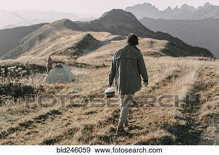 Caucasian man carrying bucket of snow to tent on mountain View Large Photo Image Stock Photo - Caucasian man carrying bucket of snow to tent on mountain. Fotosearch