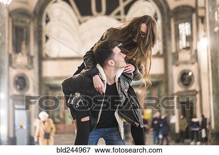 Caucasian man carrying woman piggyback in lobby View Large Photo Image Stock Photo - Caucasian man carrying woman piggyback in lobby. Fotosearch