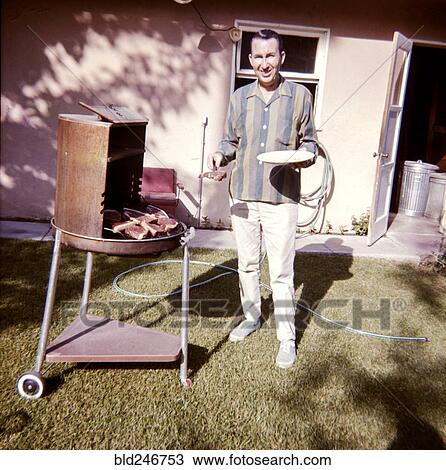 Caucasian man cooking meat on barbecue in yard View Large Photo Image Stock Image - Caucasian man cooking meat on barbecue in yard. Fotosearch