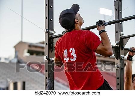 Caucasian man doing chin-ups outdoors View Large Photo Image Stock Image - Caucasian man doing chin-ups outdoors. Fotosearch