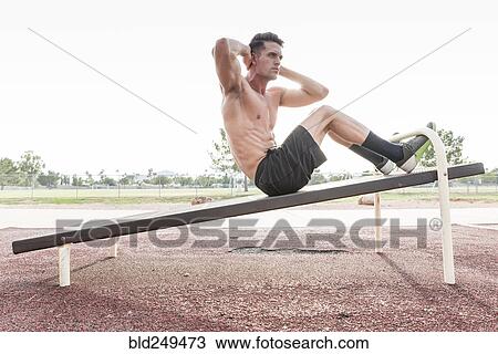 Caucasian man doing sit-ups outdoors View Large Photo Image Stock Image - Caucasian man doing sit-ups outdoors. Fotosearch