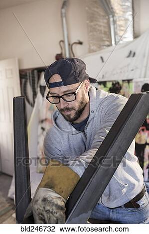 Caucasian man examining metal sculpture View Large Photo Image Stock Image - Caucasian man examining metal sculpture. Fotosearch