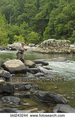 Picture - Caucasian man fishing in river. Fotosearch