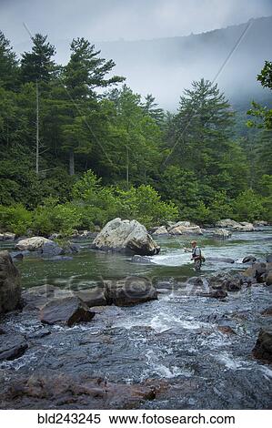 Stock Photography - Caucasian man fishing in river. Fotosearch
