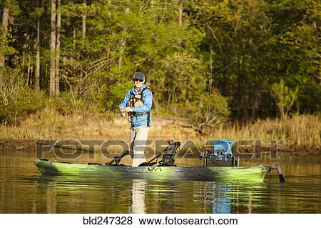Caucasian man fishing on kayak View Large Photo Image Stock Photo - Caucasian man fishing on kayak. Fotosearch