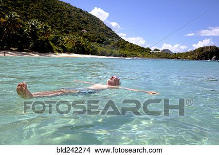 Picture - Caucasian man floating in tropical ocean. Fotosearch