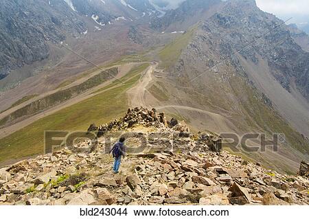 Picture - Caucasian man hiking on mountain rocks. Fotosearch