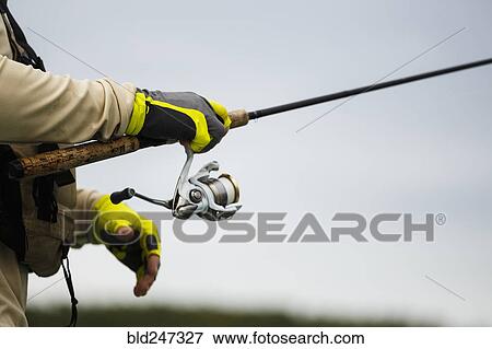 Stock Photo - Caucasian man holding fishing rod. Fotosearch