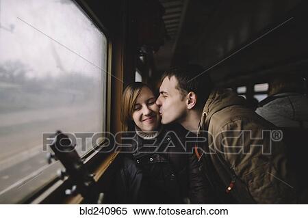 Caucasian man kissing woman on cheek in train View Large Photo Image Stock Photography - Caucasian man kissing woman on cheek in train. Fotosearch