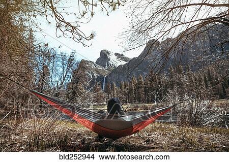 Caucasian man laying in hammock near mountains View Large Photo Image Picture - Caucasian man laying in hammock near mountains. Fotosearch