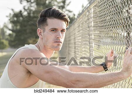 Caucasian man leaning on fence and resting View Large Photo Image Picture - Caucasian man leaning on fence and resting. Fotosearch