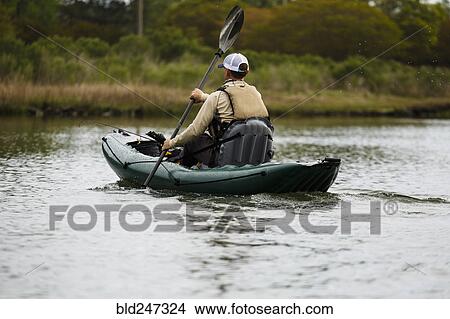 Picture - Caucasian man paddling kayak. Fotosearch