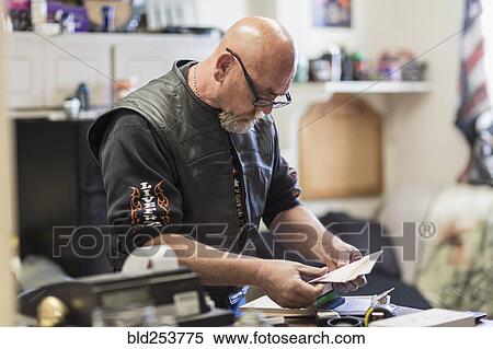 Stock Photography - Caucasian man reading paperwork on clipboard. Fotosearch