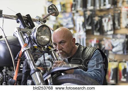 Caucasian man repairing motorcycle View Large Photo Image Stock Photo - Caucasian man repairing motorcycle. Fotosearch