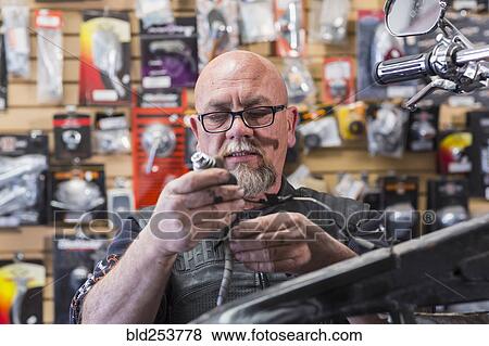 Caucasian man repairing motorcycle View Large Photo Image Stock Photo - Caucasian man repairing motorcycle. Fotosearch