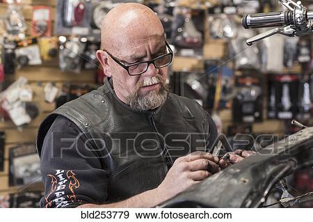Caucasian man repairing motorcycle View Large Photo Image Stock Photo - Caucasian man repairing motorcycle. Fotosearch
