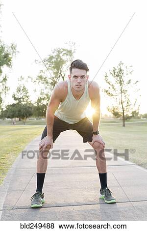 Stock Photo - Caucasian man resting on path in park. Fotosearch
