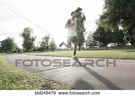 Caucasian man running on path in park View Large Photo Image Stock Photo - Caucasian man running on path in park. Fotosearch