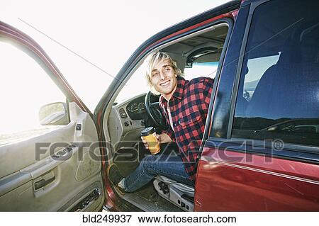 Caucasian man sitting in cat holding coffee cup View Large Photo Image Stock Photo - Caucasian man sitting in cat holding coffee cup. Fotosearch