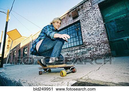 Caucasian man skateboarding on urban sidewalk View Large Photo Image Stock Image - Caucasian man skateboarding on urban sidewalk. Fotosearch