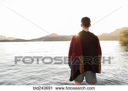 Stock Image - Caucasian man standing at river. Fotosearch