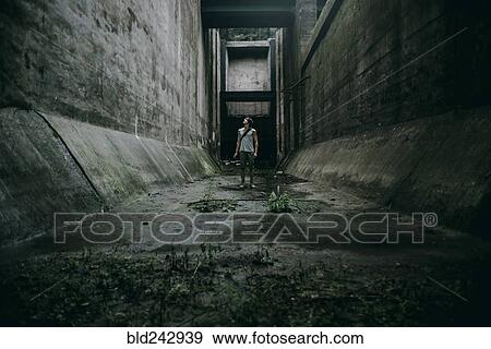 Caucasian man standing in concrete alley View Large Photo Image Stock Photo - Caucasian man standing in concrete alley. Fotosearch
