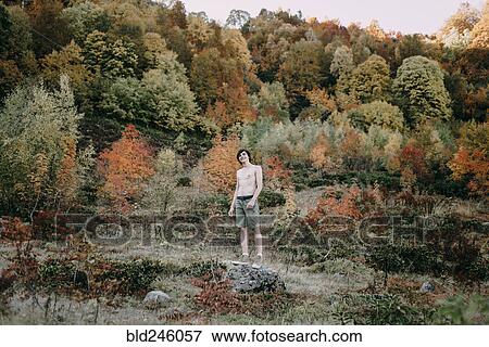 Stock Photo - Caucasian man standing on rock in autumn. Fotosearch