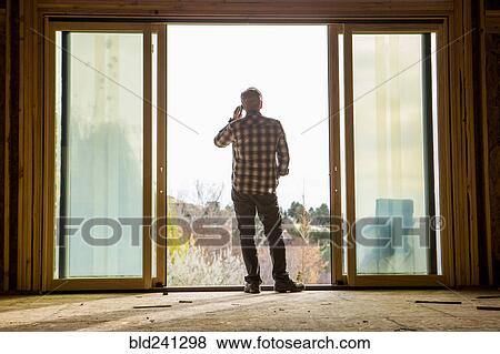 Caucasian man talking on cell phone in doorway View Large Photo Image Stock Photo - Caucasian man talking on cell phone in doorway. Fotosearch