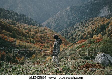 Picture - Caucasian man walking in valley. Fotosearch