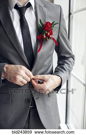 Stock Photo - Caucasian man wearing corsage fasting suit jacket button. Fotosearch
