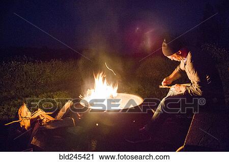 Caucasian man whittling wood near campfire at night View Large Photo Image Stock Image - Caucasian man whittling wood near campfire at night. Fotosearch