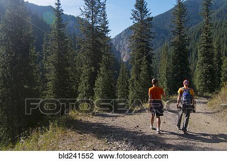 Stock Image - Caucasian men hiking on path in mountains. Fotosearch
