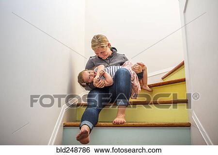 Stock Photograph - Caucasian mother and daughter playing on multicolor staircase. Fotosearch