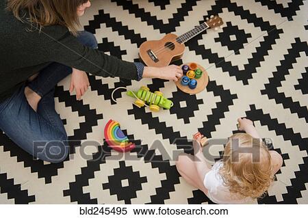 Caucasian mother and daughter sitting on floor playing with toys View Large Photo Image Stock Photography - Caucasian mother and daughter sitting on floor playing with toys. Fotosearch
