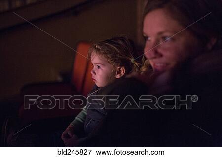 Caucasian mother and daughter watching movie in theater View Large Photo Image Stock Photo - Caucasian mother and daughter watching movie in theater. Fotosearch