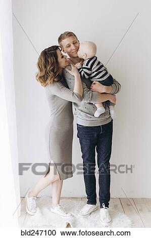 Stock Image - Caucasian mother and father admiring baby son. Fotosearch