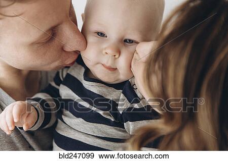 Caucasian mother and father kissing baby son on cheek View Large Photo Image Stock Photo - Caucasian mother and father kissing baby son on cheek. Fotosearch