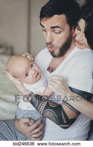 Stock Photograph - Caucasian mother and father playing with baby son. Fotosearch