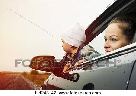 Stock Image - Caucasian mother and son looking out car window. Fotosearch