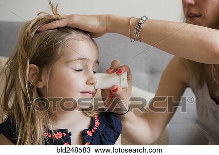 Stock Image - Caucasian mother applying sunscreen to face of daughter. Fotosearch