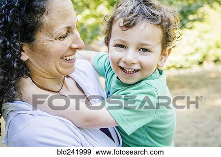 Caucasian mother carrying smiling son View Large Photo Image Stock Photo - Caucasian mother carrying smiling son. Fotosearch