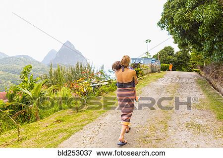 Stock Photo - Caucasian mother carrying son on dirt path. Fotosearch