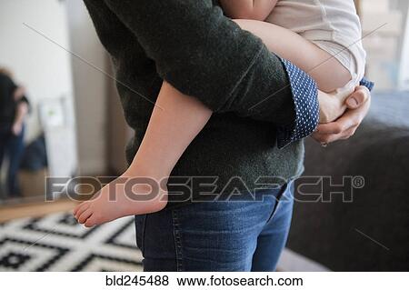 Caucasian mother holding daughter View Large Photo Image Stock Photo - Caucasian mother holding daughter. Fotosearch
