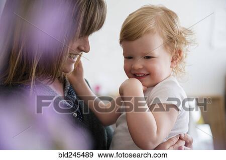 Caucasian mother holding laughing daughter View Large Photo Image Stock Photo - Caucasian mother holding laughing daughter. Fotosearch