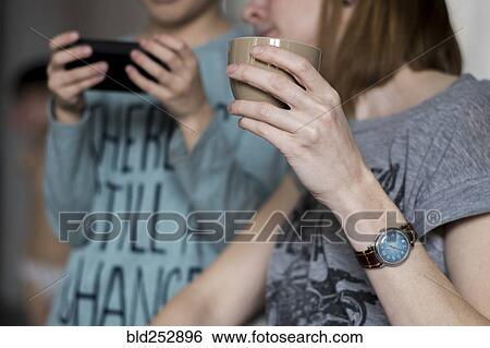 Caucasian mother watching son using cell phone View Large Photo Image Stock Photograph - Caucasian mother watching son using cell phone. Fotosearch