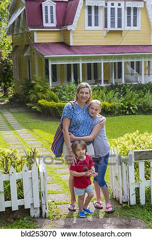 Stock Image - Caucasian mother with son and daughter in front view house. Fotosearch
