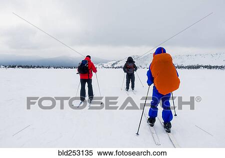 Stock Photography - Caucasian people cross-country skiing in field. Fotosearch