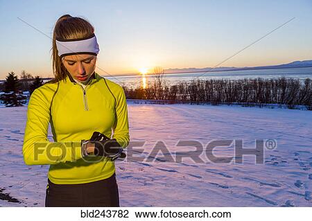 Stock Image - Caucasian runner checking the time on wristwatch. Fotosearch