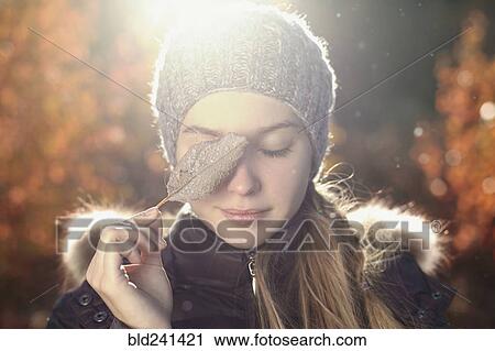 Caucasian teenage girl covering eye with leaf View Large Photo Image Stock Image - Caucasian teenage girl covering eye with leaf. Fotosearch